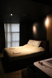a bed in a dark room with a window at King’s Apartment in Korçë