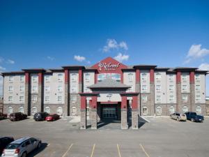 duży budynek z parkingiem przed nim w obiekcie Redwood Inn & Suites w mieście Clairmont