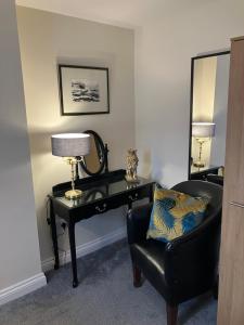 a room with a desk and a chair and a lamp at THE OCEAN SUITE - 2 minute walk to the lovely beach front promernade of llandudno in Llandudno