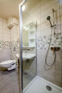a bathroom with a shower and a toilet and a sink at Fürdő Hotel*** Zalakaros in Zalakaros