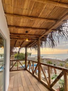 een houten veranda met uitzicht op het strand bij 9 Lunas in Zorritos