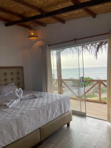 een slaapkamer met een bed en uitzicht op de oceaan bij 9 Lunas in Zorritos