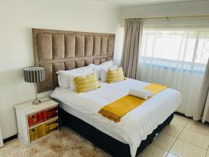 una camera da letto con un grande letto con cuscini gialli di Safi Luxury Self-Catering Suite 8 a East London
