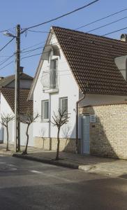 a white house with a window and a brick wall at Raba92 Apartman House in Győr