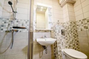 a bathroom with a sink and a shower and a toilet at Fürdő Hotel*** Zalakaros in Zalakaros