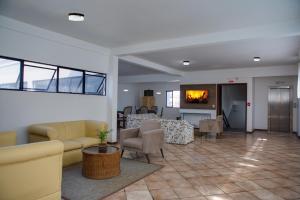 a living room with couches and chairs and a fireplace at Flipper Hotel in Laguna