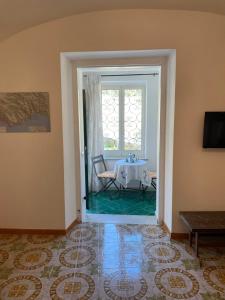 una sala da pranzo con tavolo e finestra di The White Mulberry Tree a Ravello