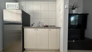 a kitchen with a stainless steel refrigerator and a microwave at White Horse Motel in Lake Worth