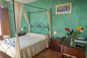 - une chambre avec un lit et un vase de fleurs dans l'établissement B&B Villa Barbarossa, à Petrignano