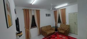 a living room with two chairs and a television at Myrol Homestay Kulim in Kulim