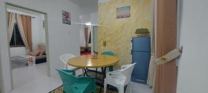 a room with a table and chairs and a refrigerator at Myrol Homestay Kulim in Kulim