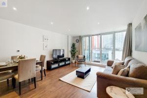 uma sala de estar com um sofá e uma sala de jantar em Fully Serviced Two Bed Apartment by ExCeL & O2 em Londres