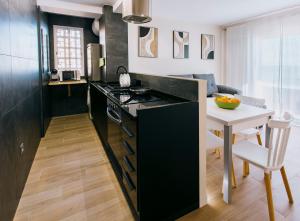 a kitchen with a black counter and a table at A Casa Martinez Playa Sin Ascensor in Mareny Barraquetas