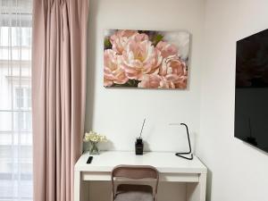un escritorio con una silla y una flor rosa en la pared en MM D Home Apartment, en Budapest