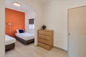 1 dormitorio con 2 camas, tocador y espejo en Omega Apartment, en Setúbal
