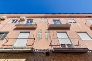 Edificio alto de color marrón con ventanas y balcones en Omega Apartment, en Setúbal