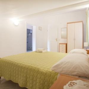 una camera con un letto con una coperta gialla di Apartments Zaharija a Rovigno (Rovinj)
