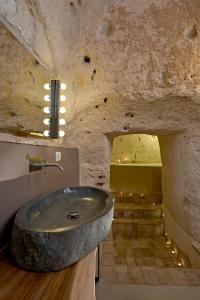 y baño con lavabo de piedra en una pared de piedra. en Ai Terrazzini en Matera