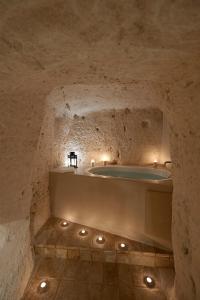 a stone bathroom with a tub in a cave at Ai Terrazzini in Matera