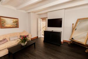 a living room with a couch and a flat screen tv at Chateau Hotel in New Orleans