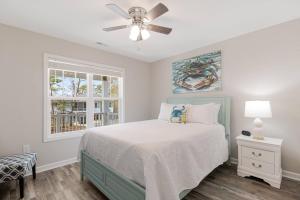een slaapkamer met een bed en een plafondventilator bij Ruff-Tide in Oak Island +42 foto's
