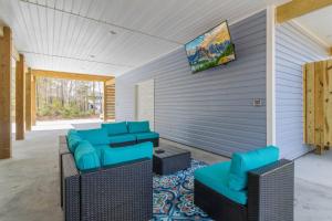 een woonkamer met blauwe stoelen en een tv aan de muur bij Ruff-Tide in Oak Island