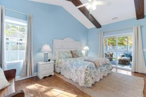 een blauwe slaapkamer met een bed en een raam bij The Cottage at Arbor Creek in Southport