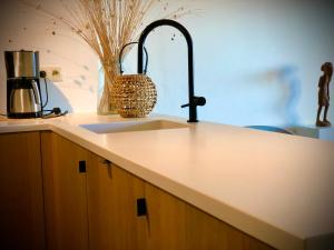 a kitchen counter with a sink and a counter top at Appartement Seaview Bunnenplein in Knokke-Heist