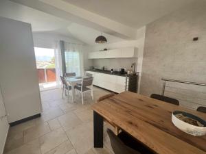 eine Küche und ein Esszimmer mit einem Holztisch in der Unterkunft Casa Vacanze Zeffiro vista mare con giardino in Àrbatax
