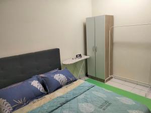 una camera da letto con un letto con cuscini blu di Abie's Homestay Putrajaya a Putrajaya