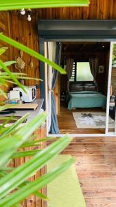 Blick auf ein Schlafzimmer mit einem Bett und einer Pflanze in der Unterkunft Ô Palm : dans un petit écrin de verdure in Saint-Joseph