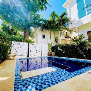 una piscina frente a una casa con palmeras en Summer House Inn San Andres, en San Andrés