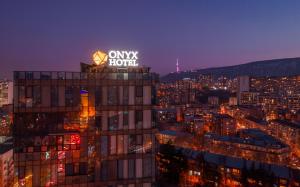 a building with a sign on top of it at night at Onyx City Center in Tbilisi City