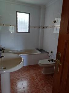 y baño con bañera, aseo y lavamanos. en Casa Agner, en Adsubia