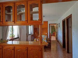 cocina con armarios de madera y comedor en Casa Agner, en Adsubia