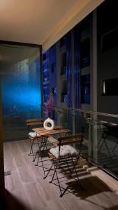 a table and chairs on a balcony at night at Luxury apartment in Muscat Hills in Muscat