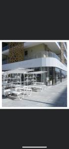 un grupo de mesas y sillas frente a un edificio en Luxury apartment in Muscat Hills, en Mascate