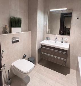 y baño con aseo, lavabo y espejo. en Luxury apartment in Muscat Hills en Mascate