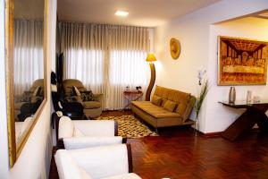 a living room with a couch and chairs in it at Apartamento Gutierrez 1 in Belo Horizonte
