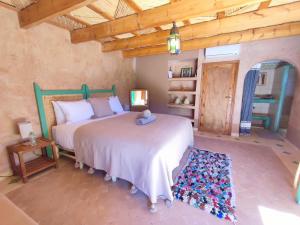 a bedroom with two beds and a wooden ceiling at Maison d'hôtes Tigminou - Adults Only in Aït Benhaddou