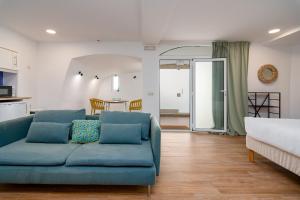 a living room with a blue couch and a kitchen at Setúbal Downtown Blue in Setúbal