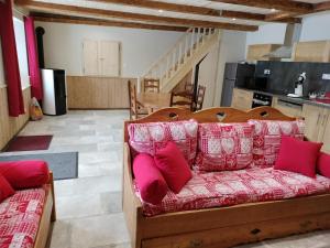a living room with a couch with pink pillows at ô Doux Comtois in Les Fourgs