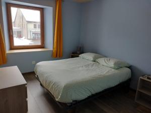 um quarto com uma cama e uma janela em ô Doux Comtois em Les Fourgs
