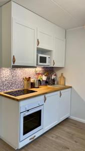 a kitchen with white cabinets and a stove top oven at Studio apartment in Pärnu