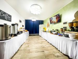 un restaurante con mesas blancas y una barra con comida en Sea Angel, en Beverley Beach