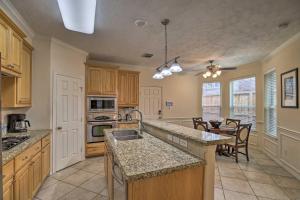 a kitchen with wooden cabinets and a dining room at 2,500 Sq Ft Townhome - Walk to Central River Oaks! in Houston