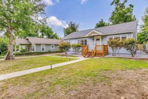 a white house with a porch and a yard at The East Hill Escape, A Bay View Beachy Cottage in Pensacola