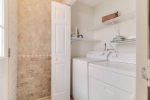 a white laundry room with a washer and dryer at The Hairy Crab in Oak Island +40 photos