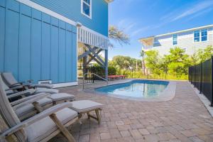 a patio with chairs and a swimming pool at Naut A Bad Gig in Oak Island
