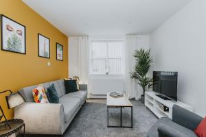 uma sala de estar com um sofá e uma televisão em Spacious Apartment Near City Centre - Free Parking, Wi-Fi with King Size Bed em Nottingham